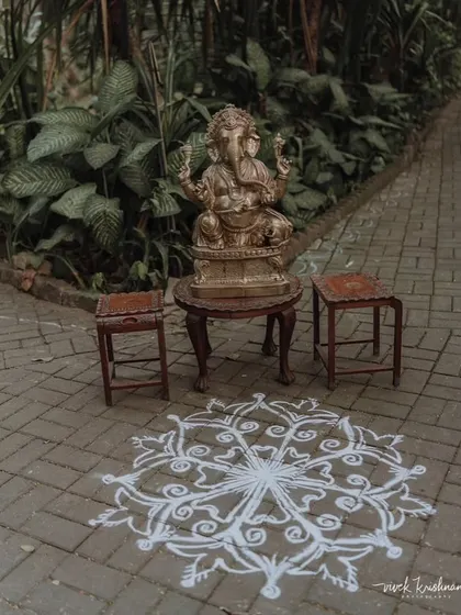 A statue of Lord Ganesha placed at the entrance with a traditional 'kolam' or 'rangoli' design, to welcome guests and bless the union.