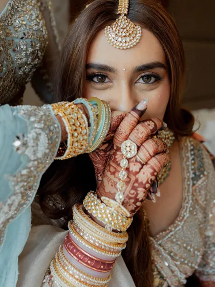 A close-up on the bride's hands, adorned with henna and bangles. We focus on these beautiful details that are an important part of the wedding story.