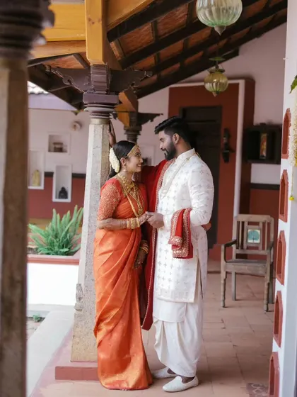 An intimate moment between the couple on the veranda of a traditional house, a perfect setting for their South Indian wedding photography.