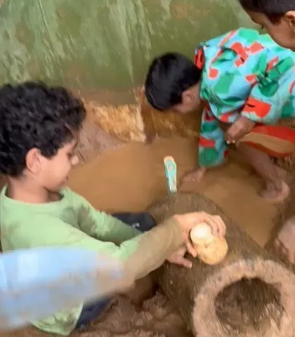 Two children are completely absorbed in their muddy creations in the sandpit, a perfect example of deep, uninterrupted free play.