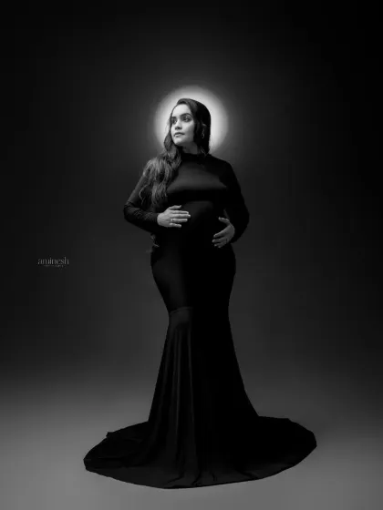 Sometimes, a simple portrait is the most powerful. Using dramatic studio lighting and a classic black and white finish, I focus entirely on the mother's strength and beauty during her pregnancy.