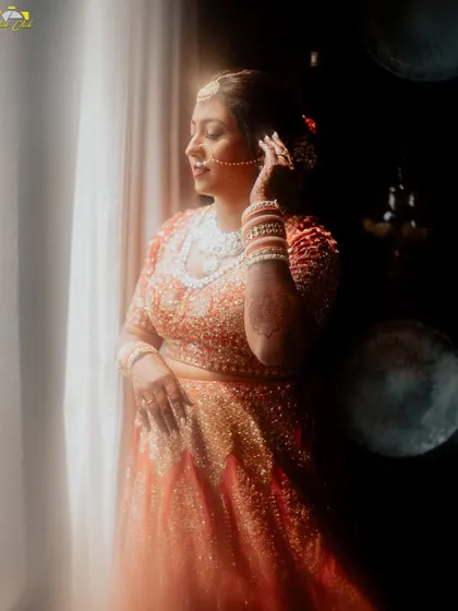 A beautiful portrait of the bride by the window. The natural light illuminates her features and her stunning jewelry, creating a classic and elegant shot.