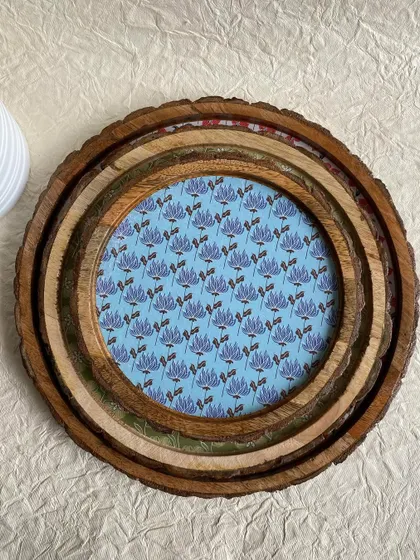 A top-down view of the nested wooden log trays, each with a different vintage floral design.