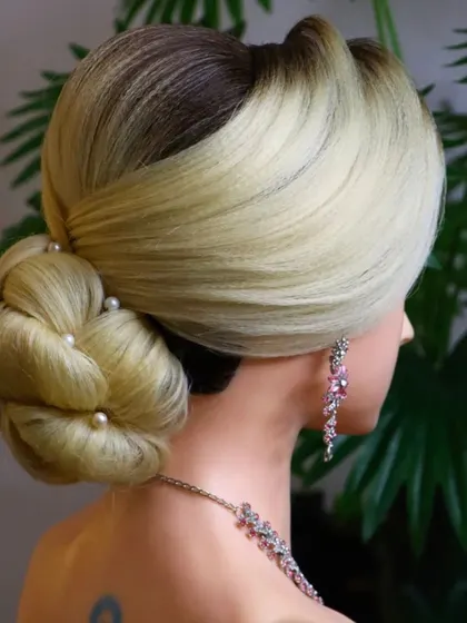 Another view of the knot bun, showing how it can be styled with a side parting and soft front layers. Versatility is key in professional hairstyling.