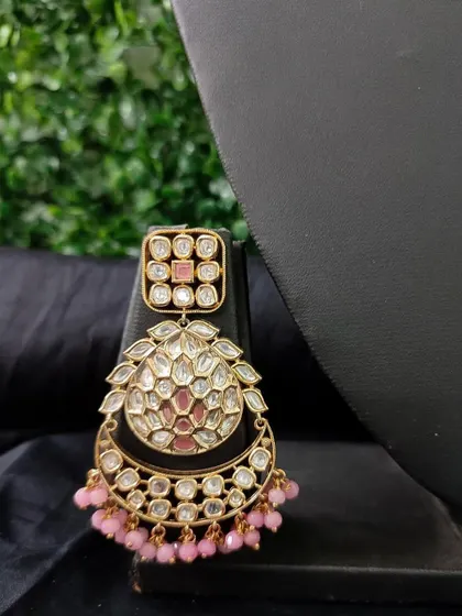 A beautiful chandbali earring with pink enamel and kundan work. The dangling pink beads add a playful touch to this rental piece.