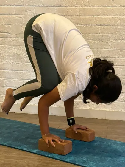 Our TTC program is designed for all body types and levels of experience. Here, a student works on her Bakasana, showing that with the right technique and support, advanced poses are within reach for everyone.