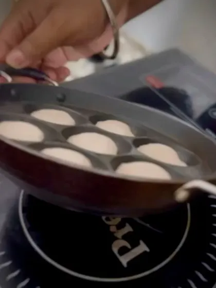 Preparing fresh batter in a paniyaram pan, a glimpse into the creation of a South Indian specialty.