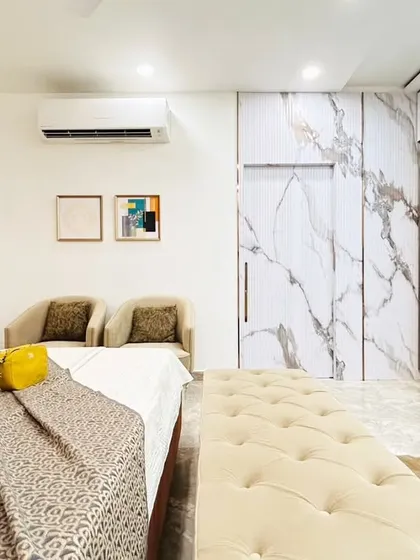 This angle highlights the stunning white marble-finish wardrobe doors, which add a touch of luxury and reflect light beautifully. The clean lines and metallic handles complete the modern look.