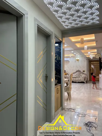 This entryway features a stunning backlit ceiling with a geometric pattern and custom doors with gold inlay. It creates a memorable first impression.