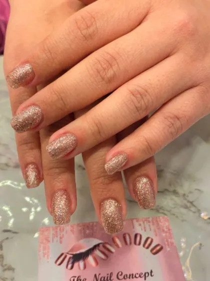 A full set of dazzling rose gold glitter nails. These short, square-shaped nails are perfect for when you want a simple design that still makes a big impact.