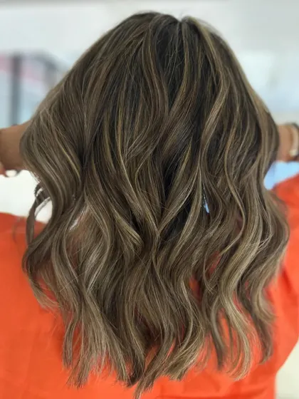 Hello summer. This beach blonde balayage on a textured, mid-length cut is ready for sun and waves.
