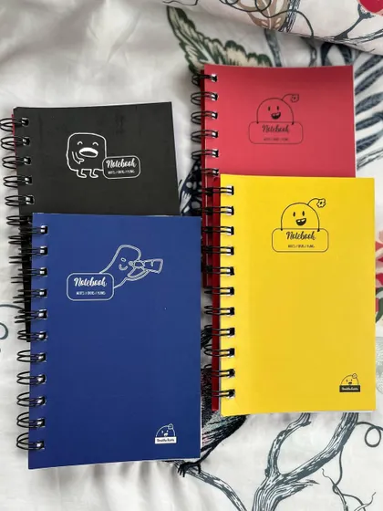 A collection of my 6x4 inch notebooks in four different colors, each with a simple and cute doodle on the cover.