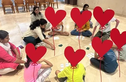 A group of parents and children sitting in a circle on the floor, deeply engaged in a math game. This setup fosters a sense of community and shared learning.