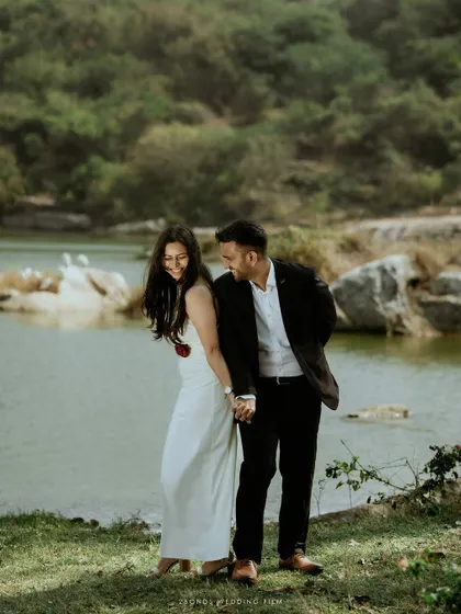 A candid moment of laughter and connection as the couple holds hands by the lakeside, their joy reflecting in the tranquil water.