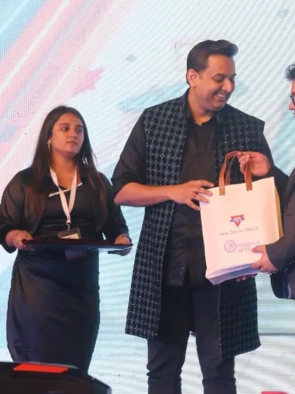 A guest is presented with a gift bag, acknowledging their contribution to our annual fashion show.
