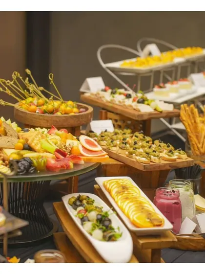 Another angle of our lavish buffet, showcasing caprese skewers, fruit platters, and various small bites, demonstrating the breadth of our menu.