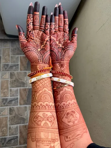 The gorgeous, deep red stain of a bridal mehendi, adorned with traditional Bengali wedding bangles (shakha pola).