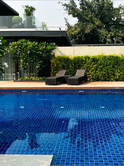 The same lounge chairs from a different angle, ready for sunbathing by the beautiful blue pool.