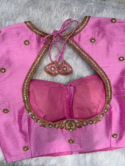 The back of the pink blouse, featuring a teardrop-shaped cutout with delicate tassels.
