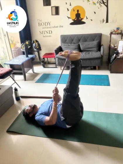 A client uses a yoga strap for a reclined hamstring stretch. This is a safe and effective way to increase flexibility in the back of the legs without straining the lower back.