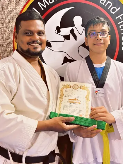This student earns his green belt, showing his progression and commitment to mastering Taekwondo techniques.
