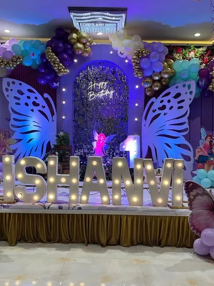 Another view of the butterfly stage, showing the placement of smaller butterfly props and the marquee letters spelling out the birthday girl's name.