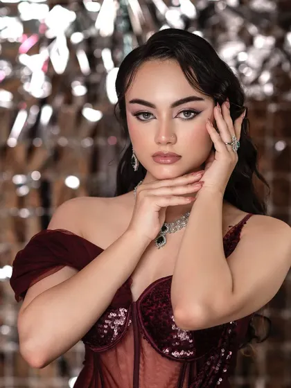 This portrait, with its dramatic winged eyeliner and contoured features, is a perfect example of a high-glam makeup look. The lighting is crafted to accentuate the cheekbones and jawline.