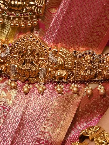 The vaddanam, or waist belt, is essential for completing the bridal silhouette. This one features a central Lakshmi motif surrounded by peacocks.