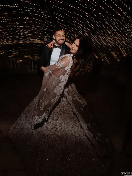 A magical moment under a tunnel of fairy lights. This shot captures the romance and fantasy of an engagement night, with the couple lost in a dance.