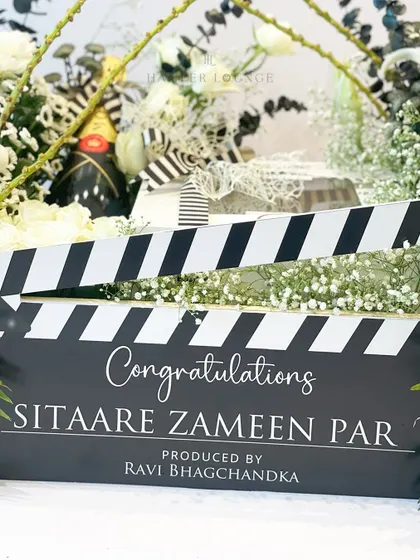 The custom clapperboard for the movie-themed hamper, with "Congratulations Sitaare Zameen Par" elegantly written. It's a standout piece that makes the gift truly unique.
