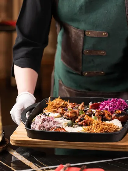 Our server presents the gourmet chicken wings, ready to be enjoyed. Every dish is served with care and a touch of theatricality.