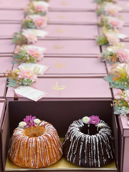 My twin cake sets are perfect for return favors or when you simply can't choose just one. Pictured here are my vanilla and chocolate bundt cakes, drizzled with icing and packed in beautiful pink gift boxes adorned with fresh flowers.