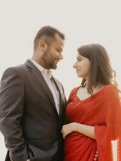 A simple and classic portrait of a couple against a bright, open sky. The focus is entirely on their connection, creating a clean and timeless image from their pre-wedding shoot.