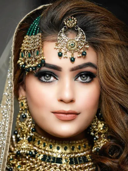 A captivating close-up bridal portrait. The focus is on the bride's striking eyes and the exquisite details of her makeup and jewelry, creating a powerful and beautiful image.