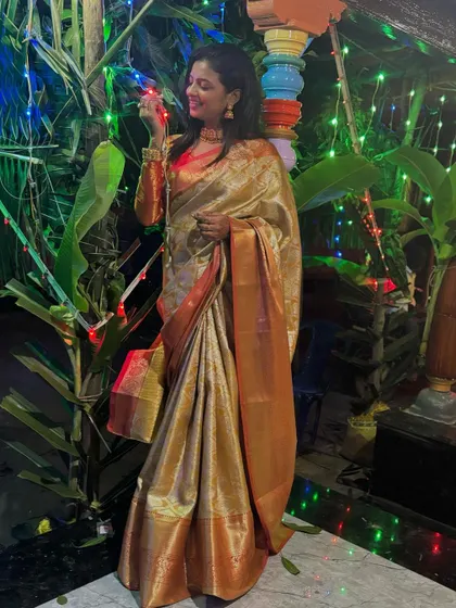 Sonu celebrating at night, the festive lights complementing the shimmer of her silk saree.