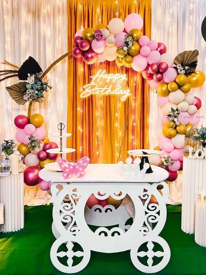 Turning a dream into reality for a 4th birthday party. This setup features a fairytale carriage table, a golden arch with pink and gold balloons, a "Happy Birthday" neon sign, and a large marquee number.