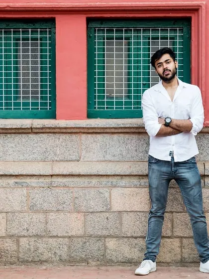 An outdoor portrait of a man standing confidently against a colorful urban wall. This shot showcases my approach to using environmental backdrops to create natural, candid portraits for men's fashion portfolios.