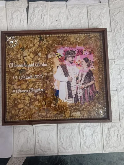 A rectangular wedding frame preserving delicate white and yellow flowers. The couple's names, wedding date, and hashtag are elegantly written on the clear resin over their photo.