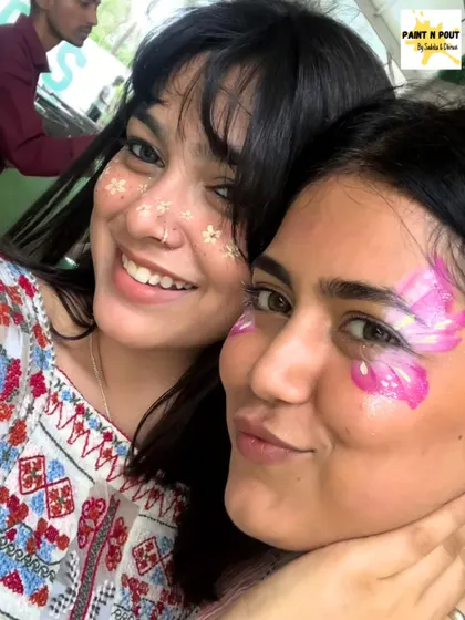 That's us, Sadeka and Dhruvi. We love getting painted just as much as our clients do. Here we are with some floral and butterfly designs.