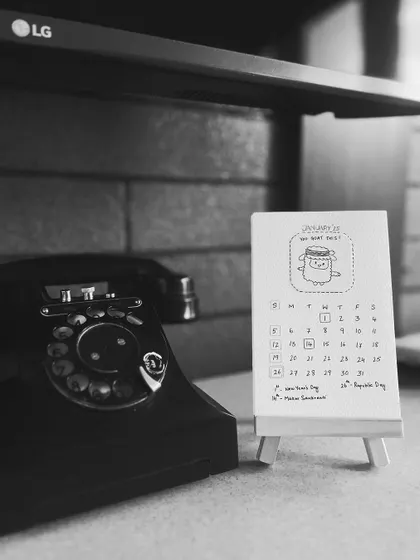 A black and white shot showing the calendar's timeless feel, placed next to a vintage rotary phone.