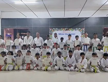 The full group of students from our Silicon City dojo posing with their new belts and certificates after a demanding but successful grading day.