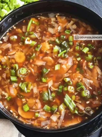 This is our Hot and Sour style soup, packed with vegetables and spring onions in a savory broth. It offers a perfect balance of spicy and tangy flavors.