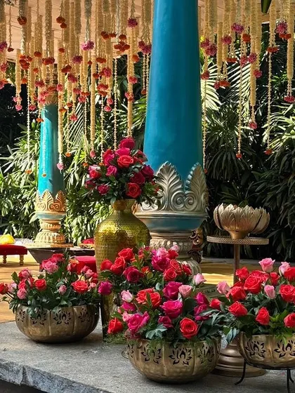 A collection of vibrant red and pink roses in ornate brass bowls, adding a pop of color and luxury.