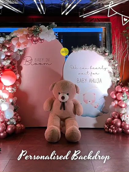 A personalized double-panel backdrop for a "Baby in Bloom" shower. The combination of two themes, "Baby in Bloom" and "We can bearly wait," made this setup extra special for the family.