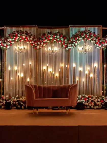 This is the kind of grand reception stage we love to create. The combination of warm lighting, cascading floral arrangements, and a dramatic backdrop makes for an unforgettable evening and stunning photographs. We can customize the scale and colors for your wedding reception.