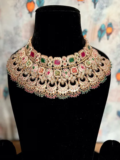 A closer look at the artistry of Meenakari. This beige Kundan necklace with ruby and emerald stones is perfect for adding a splash of color and regal elegance to your bridal or festive outfit.