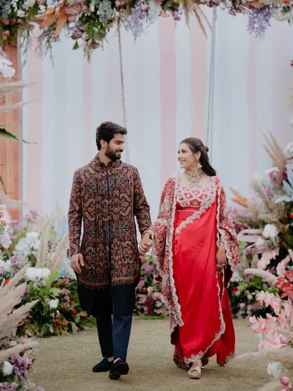 A walk to remember. The floral archway, filled with pampas grass and pastel blooms, created a dreamy entrance for the happy couple at their Mehendi.