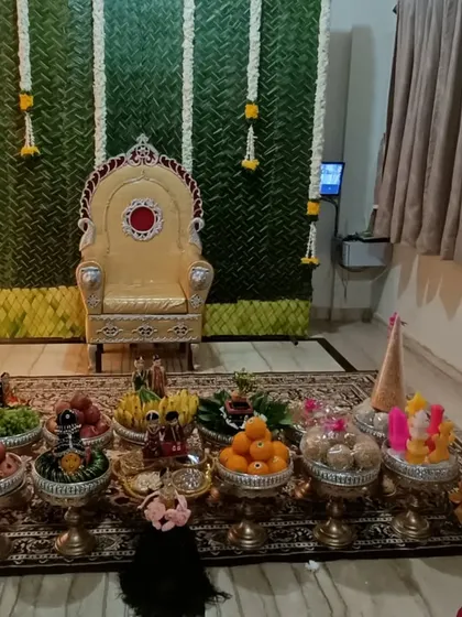 A simple and elegant platter setup for a home-based function with a paan leaf backdrop.