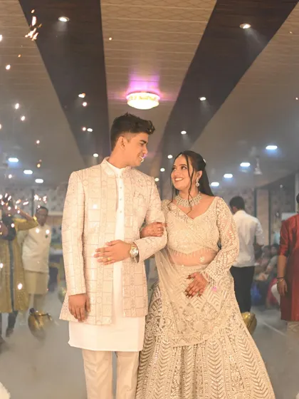 The happy couple walks through a cloud of smoke, looking picture-perfect. The bride's makeup is designed to be radiant and stand out in dramatic lighting.