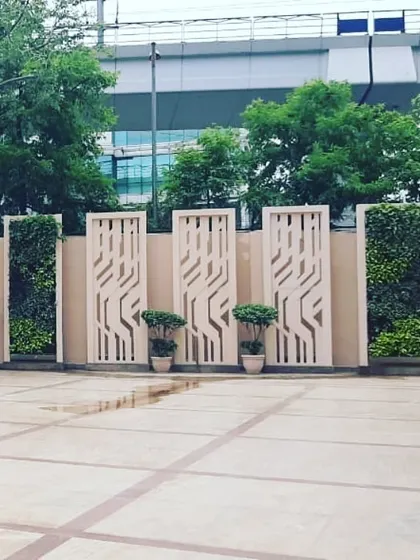 A wider view of the same project shows how the alternating pattern of green walls and decorative panels creates a dynamic and modern aesthetic. This is an effective way to enhance the landscape design of corporate campuses or public plazas.